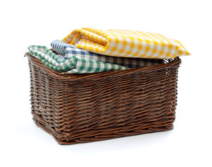 Clothes in a laundry wooden basket isolated on white background