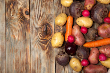 Vegetables. Potatoes, carrots, onions, beets and radishes on a rustic background