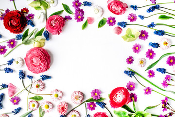 Frame of roses, muscari, chamomile, ranunculus, branches, leaves, petals and buds on white background. Flat lay, top view