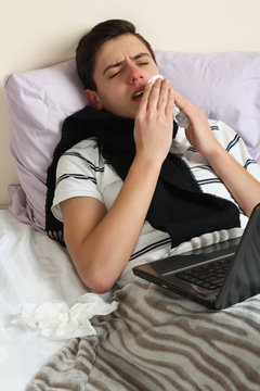 The sick man lying in bed with a cold.