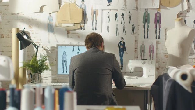  Back view of a Male Fashion Designer Working on a Personal Computer, Taking Notes
