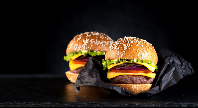 Homemade beef burger on a black background and space for text