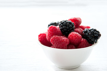 Fresh raw berries in a white bowl on a table