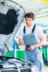 KFZ-Mechaniker mit Checkliste in Autowerkstatt