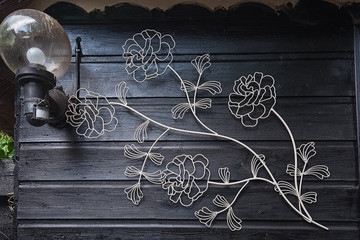 Wrought iron flowers on the wall of the house.