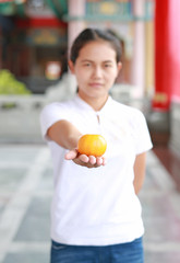 asian woman in White traditional chinese dress with holding sacred Orange at chinese temple in bangkok thailand, Chinese new year concept.