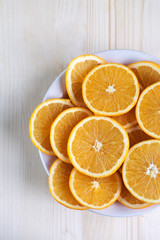 Oranges cut into slices, lay on a white plate, on wooden boards