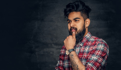 Attractive bearded Indian man in plaid fleece shirt.