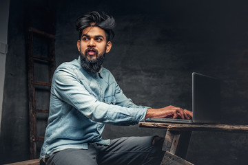 Stylish  Indian male working with laptop.