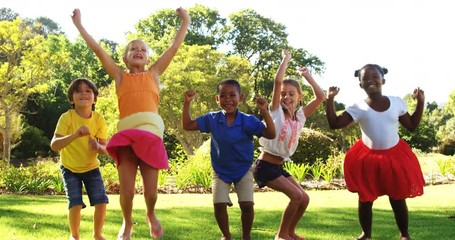 Group of kids jumping together in park on a sunny day 4k