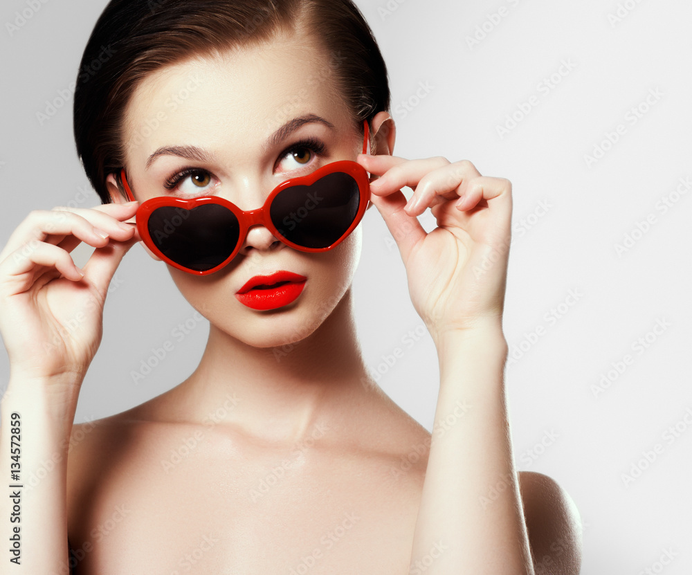 Wall mural young girl with glasses in the shape of heart. holiday makeup. beauty sexy lips. valentines day conc