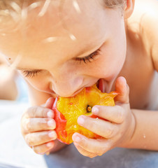 Boy eating a peach