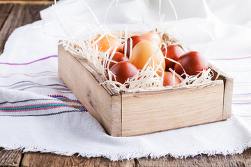 Easter red eggs in  wooden crate on rustic table