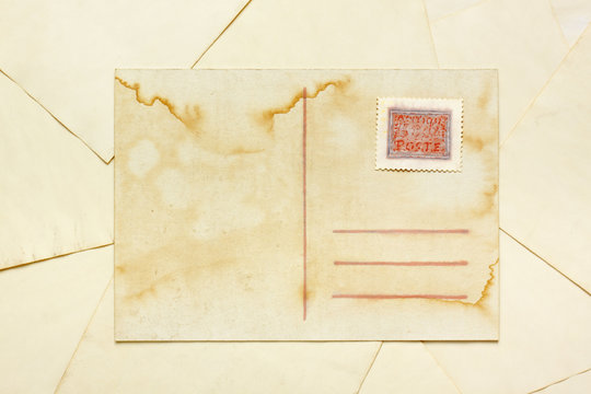 Aged empty postcard with painted abstract postage stamp