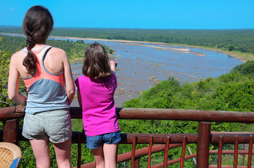 Family safari vacation in South Africa, mother and daughter looking at beautiful river view,...