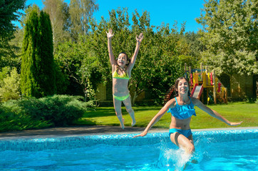 Children jump to swimming pool water and have fun, happy active kids on family vacation
