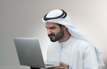 Arabian Business man looking surprised at his laptop..