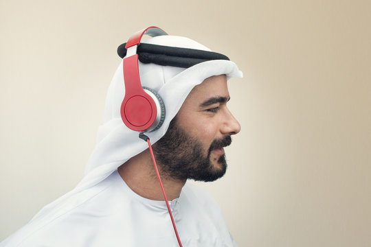 Stylish Arabian man in headphones, Arabian guy listening to music..