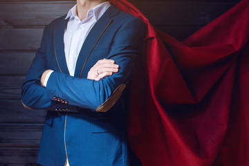 businessman standing in a suit and red cloak like superhero