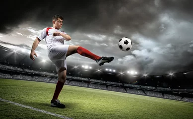 Foto op Plexiglas Football player is kicking a ball in the stadium. © efks