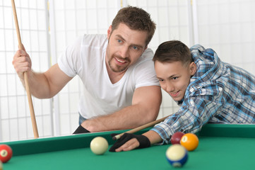 father and son playing billiard