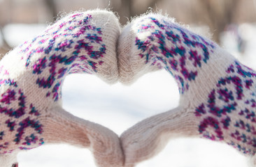 Woman making heart symbol with snowy hands