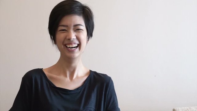 Close up laughing face of beautiful mixed race Asian woman