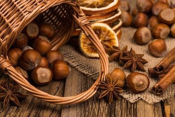 Hazelnuts in wicker basket on old wooden table.