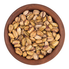 Roasted pistachio nuts in plate, isolated on white background.