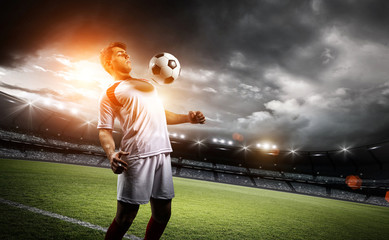 Football player withstand a ball with his chest in the stadium