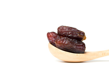 A dates in a wooden spoon isolated over white background