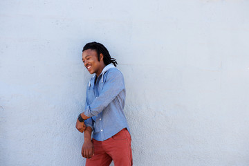 african man with dreadlocks smiling against gray background