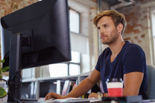 mann arbeitet im b&uuml;ro am computer