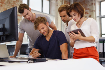 junge mitarbeiter mit computer und tablet in einer besprechung