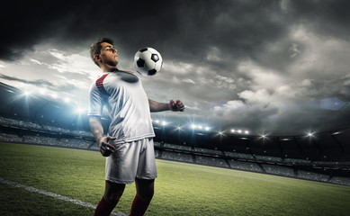 Football player withstand a ball with his chest in the stadium