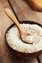 Fototapeta na wymiar Raw uncooked basmati rice in wooden bowl on table