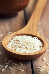 Closeup of raw uncooked basmati rice in wooden spoon