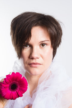 junge Frau mit Blume und kurzen braunen Haaren