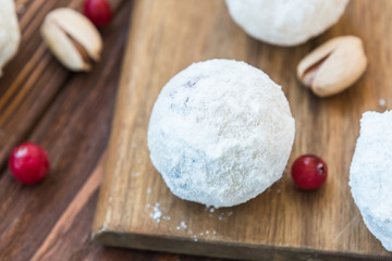 Cranberries and pistachios balls in powdered sugar