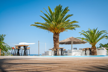 Fototapeta premium Beach with wooden umbrellas and sunbeds