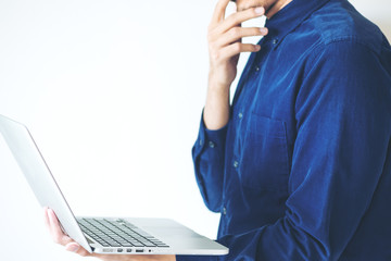 A business man using on the laptop in white room background