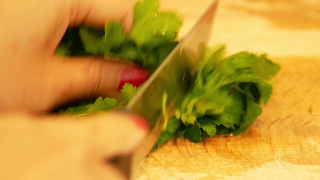cutting green pasley on a wooden board
