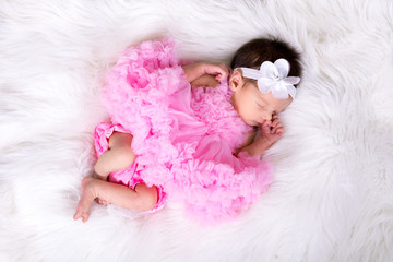 Beautiful newborn baby girl wearing a pink fluffly dress