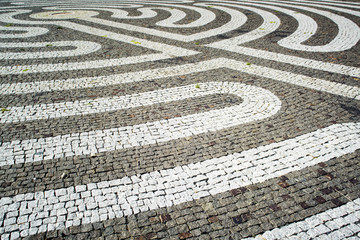 Fragment of old stone pavement cobble-stones texture as a background, top view, horizontal