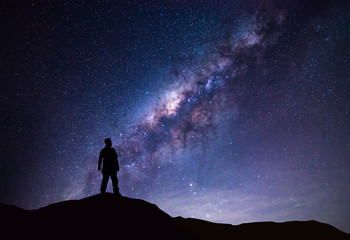 Landschaft der Milchstraße. Silhouette des glücklichen Mannes, der auf dem Berg mit Nachthimmel und hellem Stern im Hintergrund steht.