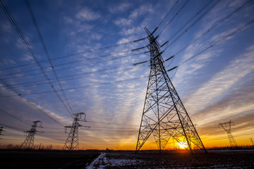 The silhouette of the evening electricity transmission pylon