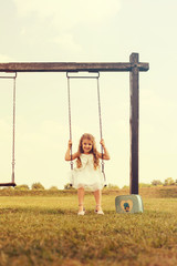 Cute Girl Swinging In Park