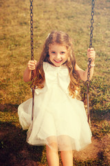 Cute Girl Swinging In Park