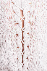 Close-up of feminine white wool sweater with pretty details