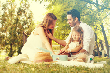 Father and mother reading book with daughter